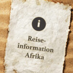 Reiseinformation für Afrikareisen Zettel im Sand